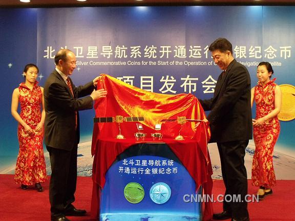 中國金幣總公司董事長徐聯(lián)初與總參測繪導(dǎo)航局衛(wèi)星導(dǎo)航定位工程辦公室主任楊寶峰共同為北斗衛(wèi)星導(dǎo)航系統(tǒng)開通運行金銀紀念幣揭幕