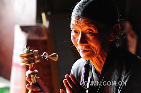 一名藏族老人在西藏自治區(qū)山南地區(qū)昌珠寺手搖轉經筒，虔誠地誦念佛經