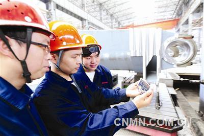 中信重工十九大代表劉新安的徒弟在工位上通過手機(jī)收看十九大開幕式實況。