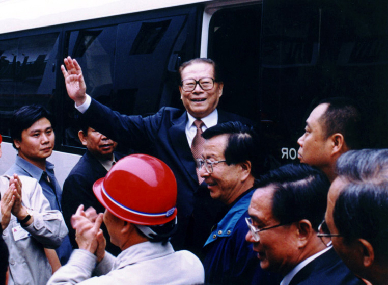 “同志們好！”“大家好！”邁出車門的江澤民向激動沸騰的西南鋁職工微笑地點頭，爽朗地問好，親切地揮手致意。（李影攝）