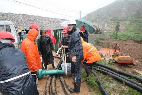 圖一為中州鋁業(yè)保障中心員工冒雨在現(xiàn)場(chǎng)搬運(yùn)潛水泵設(shè)備，以應(yīng)對(duì)未來(lái)幾天更加嚴(yán)峻的汛情。